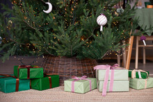 Close Up Of Gift Boxes Under The Christmas Tree Wihh Wicker Base. Christmas, New Year Concept. Selective Focus.