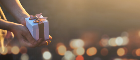 Females holding Christmas gift box decorated with Christmas and New Year banner Concept merry christmas and happy new year 2022 , 2023, 2024