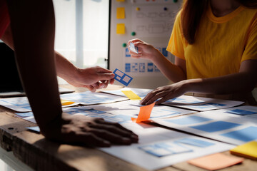 group of ux developer and ui designer brainstorming about app interface design at modern office. cre