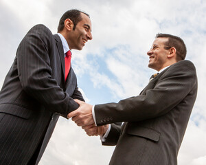 Business Partners. A warm and friendly handshake between agreeable business colleagues, low angle view. From a series of related images.