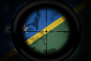 Wall Mural - sniper scope aimed at flag of Solomon Islands on the khaki texture background. military concept. 3d illustration