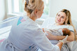 © Iryna - Female caucasian doctor and mother and newborn baby at the hospital. Breastfeeding specialist consulting new mother. Nurse bringing newborn to young happy mother in hospital.