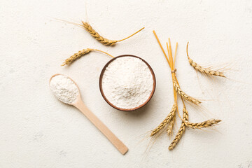 Flat lay of Wheat flour in wooden bowl with wheat spikelets on colored background. world wheat crisis