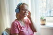 © evafesenuk - Close up senior woman in blue headphones enjoying music with her eyes closed