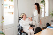 © Renata Hamuda - a businesswoman in a wheelchair laughing with her colleague in the office