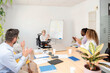 © Renata Hamuda - coworkers applaud to executive woman in wheelchair after successful presentation near the whiteboard with graphics. concept of unity of the support team