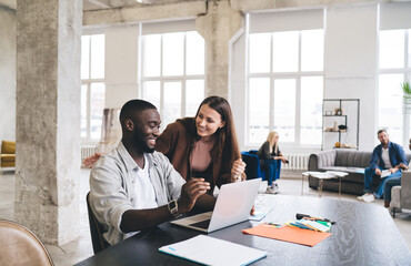 Cheerful diverse colleagues working on project in office