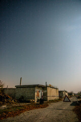 old abandoned factory forest in the night . Night landscape. Nightsky and clouds . Stars in the sky . Lights of the city . 