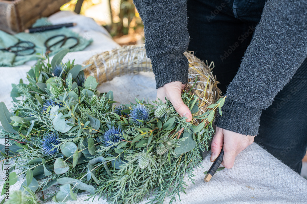 Kranz binden mit Eukalyptus, Distel, Mimose und Zypresse, Adventskranz selber machen, moderne Dekoration für Weihnachten Stock Photo