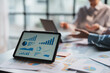 © amnaj - Businesspeople meeting and planning business strategies together in office pointing to graphs and charts using tablet to work.