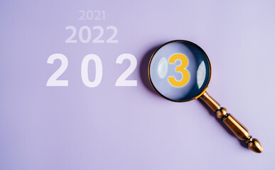 Poster - Target business on 2023 year concept. Magnifier focus to 2023 icon. planning project, invest, innovation, idea to next year from end 2022, New year concept.