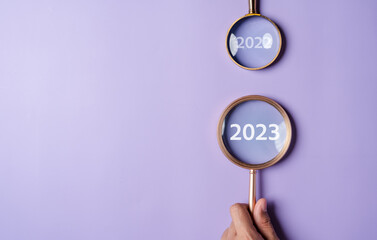 Poster - Target business on 2023 year concept. Magnifier focus to 2023 icon. planning project, invest, innovation, idea to next year from end 2022, New year concept.
