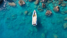 Aerial Drone Top Down Photo Of White Inflatable Rib Speed Boat Anchored In Tropical Exotic Rocky Bay With Emerald Sea