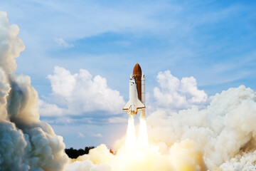 Spaceship lift off. Space shuttle with smoke and blast takes off into space on a background of blue sky. Successful start of a space mission. Elements of this image furnished by NASA.