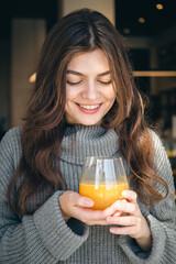 Attractive young woman with a glass of freshly squeezed orange juice.