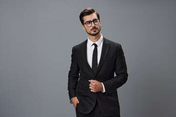 Wall Mural - Man businessman in business suit and eyeglasses with brunette beard on gray background. The concept of good business and expensive clothes a copy space