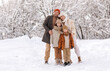 © JenkoAtaman - Happy family in warm clothes smiling at camera while playing on fresh air in winter snowy forest
