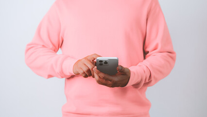Poster - Close-up of a young man standing with holding a smartphone in hands, posting in social media, typing message, playing online game, doing purchases, chatting with friends or relatives.