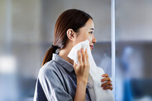 タオルで顔を拭いている女性