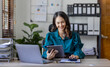 © David - Attractive smiling young asian business woman work at home office, Asian woman working on laptop computer holding tablet.