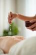 © DragonImages - Woman Pinching Salt Scrub on Back