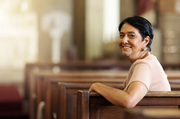 Senior woman, christian and happy in church, spiritual and religion after service, smile and lifestyle. Elderly female smile, portrait and empowerment while sitting in wood bench in catholic chapel