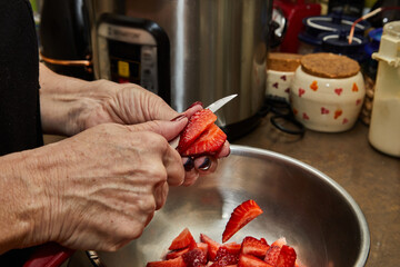 Wall Mural - Chef cuts strawberries for dessert in the home kitchen