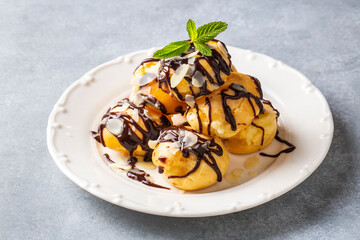 Wall Mural - Delicious profiteroles with chocolate and white plate.