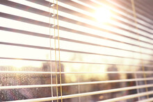 Background The Sun Shines In The Spring Through The Metal Blinds On The Window. The Texture Of The Blinds.