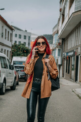 Wall Mural - red-haired woman with mobile phone in the street