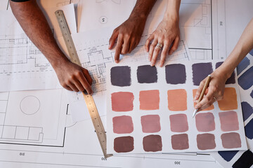 Wall Mural - Top view of two architects working on color choice for interior design project