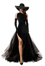 Elegant Lady In Long Black Dress And Hat. Fashion Woman In Evening Luxury Gown With Slit Over White. Mysterious Beautiful Girl Showing Sexy Leg In Flying Skirt
