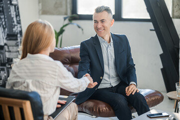 Blonde psychologist talking to a male patient at her office