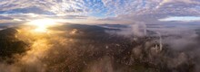 Aerial Panorama View Of Foggy Morning In An Industrial City, With Steam Coming Off The Furnaces And Cooling Towers. Old Metallurgic Factories In Resita City, Romania.