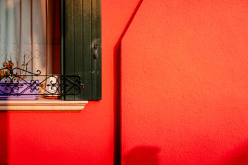 Wall Mural - Detail of red colored houses with Burano window with shadow