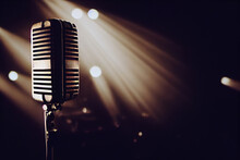 Microphone Ready On Stage Against Against Backdrop Of Spotlights And Ready For The Stand-up Or Karaoke Performer