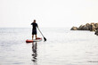 © Clàudia Ayuso - Senior man paddle surf on the beach. Male over 50 aging youthfully, paddling and doing exercise at early morning. Older adult adventurer having fun and enjoying. Peaceful and relax. Copy space.