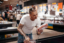 Man Choosing Meat In Grocery Store