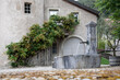 AncienFountain in the background of an old house in a Swiss village.t building and fountain in the old Swiss city. High quality photo