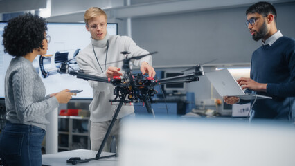 Poster - Diverse Engineers Brainstorming and Using Laptop Computer. Caucasian Male Sets Up Modern Drone. Colleagues Building, Configuring and Testing Machines. Progressive Technologies Concept.