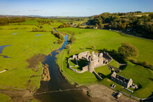 Aerial View Of Stepping Stones Over A Small River Leading To The Ruins Of An Ancient Castle (Ogmore Castle, Wales)