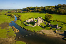 Aerial View Of Stepping Stones Crossing A Small River Leading To An Ancient Ruined Castle (Ogmore, Wales)