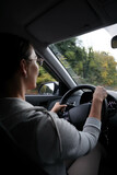 Fototapeta Tulipany - young woman driving a car on autumn road
