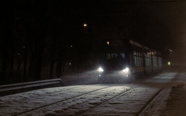 Wall Mural - Night tram in winter during a blizzard. public transport on a winter night
