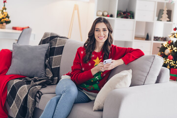 Canvas Print - Photo of young satisfied pretty woman wear stylish winter outfit sitting her favorite coach living room relax with her smartphone stay home