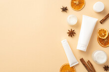 Natural Cosmetics Concept. Top View Photo Of White Tubes Without Label Cream Jars Dried Orange Slices Cinnamon Sticks And Anise On Isolated Beige Background With Empty Space