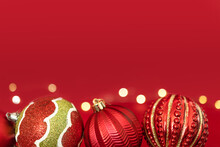 Three Christmas Red Baubles Design In A Red Background With Yellow Lights Bokeh