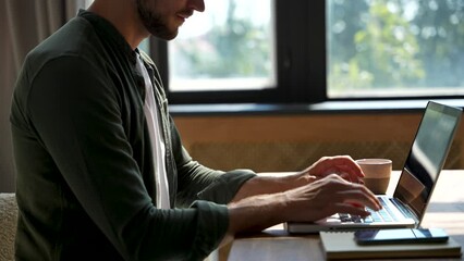 Wall Mural - Young man freelancer student using laptop studying online working from home in internet, smiling focused businessman typing on computer surfing web looking at screen enjoying distant job