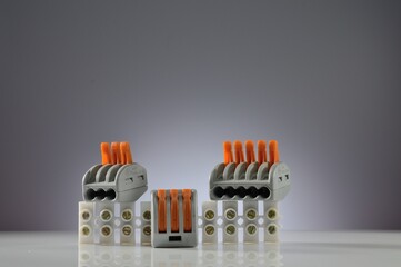 Wall Mural - Composition of electrical terminal blocks of various types. Gray gradient background. Close-up