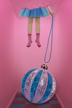 Women's Legs In Pink Socks With Blue And Pink Christmas Ball On A Pink Background
